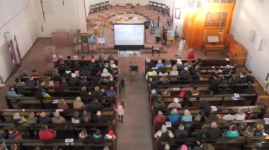 24 Şubat 2024 - Kehl, Almanya: Cemaatçiler bir Katolik kilisesinin sıralarında oturup dua ederler. Üst görünüm.