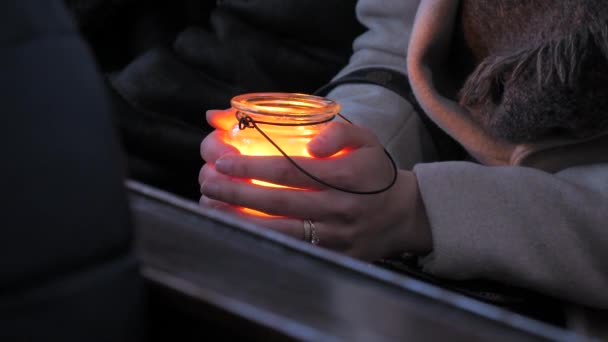 教堂的玻璃烛台上燃着一支白色的大蜡烛 脆弱的女性双手靠在蜡烛上取暖 — 图库视频影像