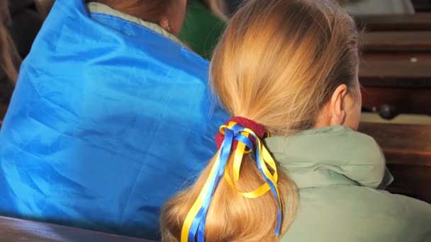 Ξανθά Μαλλιά Των Κοριτσιών Είναι Πλεγμένα Μπλε Και Κίτρινες Κορδέλες — Αρχείο Βίντεο