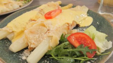 Restoranda içinde beyaz kuşkonmaz olan bir yemek. Beyaz kuşkonmaz, krep, pastırma ve sos. Gurmeler için bahar yemeği.