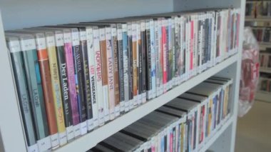 Stuttgart, Almanya - 30 Nisan 2023: Filmoteca. Farklı filmlerin olduğu sıra sıra dizilmiş raflar. DVD ortam kitaplığı.
