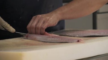 Palma de Mallorca 'daki dünyaca ünlü Olivar pazarı. Kadın elleri, ton balığı filetosunu yavaş çekimde keser. Mercado del Olivar. Balık pazarı.