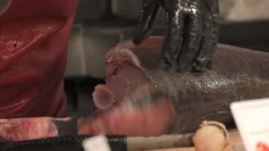 Palma de Mallorca 'daki dünyaca ünlü Olivar pazarı. Kadın elleri, ton balığı filetosunu yavaş çekimde keser. Mercado del Olivar. Balık pazarı yakın görünüm.