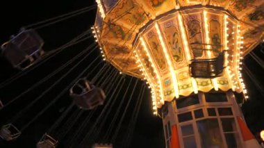 Gece vakti bir lunaparkta ağır çekimde atlı karınca. Eğlence parkında tatil eğlencesi.