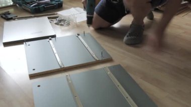 Matkabın yakın çekim görüntüsü. Adamın biri evdeki tahtaya vidayla vuruyor..