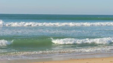 Okyanus dalgalarının yuvarlanıp sahile çarpıp büyüleyici ve sakinleştirici doğal bir manzara yarattıkları güzel, yavaş çekim görüntüleri. Turkuaz sular ve beyaz köpük çarpıcı bir şekilde yakalanıyor.