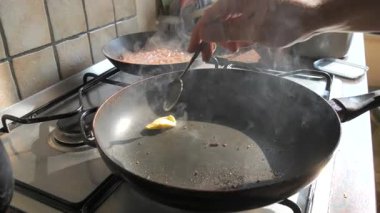 Bir kaşık cızırdayan sıcak tavaya bir parça tereyağı ekler, zengin bir buhar girdabı yaratır. Güneşli bir mutfakta ağır çekimde yakalanmış. Bu yakın çekim sahnesi yemek içeriği, yemek tarifi tanıtımı ve atmosferik pişirme videoları için ideal.