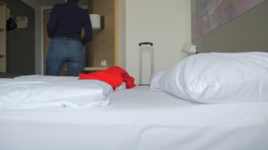 Kırmızı paltolu bir kadın elinde bavulla otel odasının kapısının yanında duruyor ve gitmeye hazırlanıyor. Ağır çekimde yakalanan sahne, huzurlu ve yansıtıcı bir yolculuk anı gösteriyor. Otel kasası, solo seyahat, şık bir yolculuk ya da yeni bir şey için ideal.