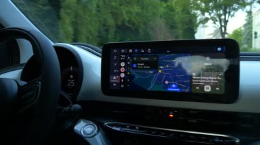 Kehl, Almanya - 27 Juli 2025: Entegre Google Maps navigasyonu ve müzik akış arayüzü olan dijital bir araç paneline yakın çekim. Modern sürüş teknolojisi ve bilgi işleme sistemi