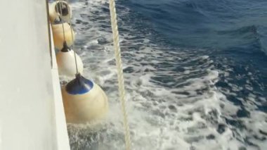 Köpüklü Adriyatik dalgalarıyla kaplanmış beyaz ve mavi tekne çamurlukları. Bir denizcilik yakın çekim hareketi ve dokusu.