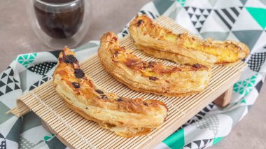 Muzlu Süt Pastası, muz, süt, yumurta rendelenmiş peynir ve çikolatadan yapılır..