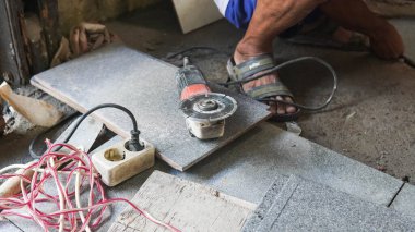 Düz tavan kesici ve elektrikli kesici. Düz tavan kesici ve elektrikli kesici. İnşaat alanında çalışan işçiler tavanı açı öğütücüsüyle kesiyor..