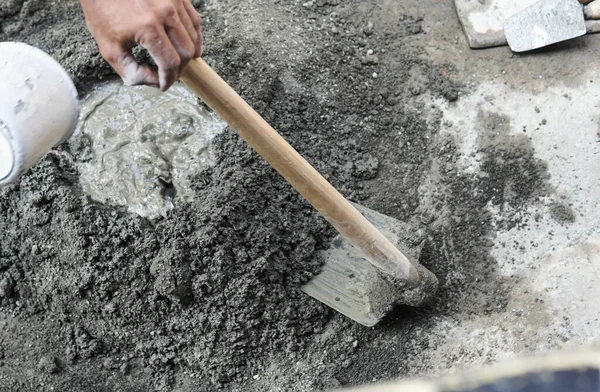 砂とセメントの力の混合の鍬を使用してアジア人労働者 ストック写真