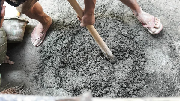 砂とセメントの力の混合の鍬を使用してアジア人労働者 ロイヤリティフリーのストック画像