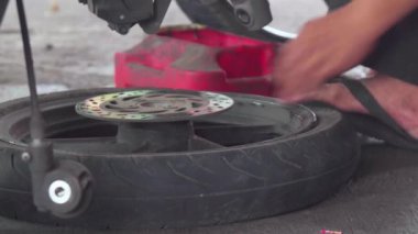 Atölye garajında motosiklet tamir eden genç adam tamirhanede motosiklet tamir eden adam, mekanik hobi ve tamirat konseptleri.