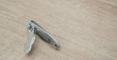 Paslanmaz çelik tırnak makası ahşap arka planda izole edilmiş.