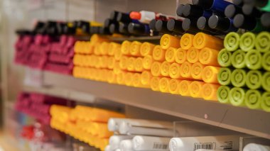 Bir mağaza vitrininde raflarda düzgünce istiflenmiş renkli işaretler. Okul gereçleri, sanat malzemeleri, sabit ve perakende konseptleri için mükemmel..