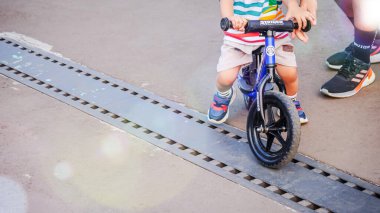 Siyah tekerli beyaz bisiklet ve betonun üzerinde koltuk. Çocuksu tasarımlar, kentsel sahneler veya ulaşım kavramları için mükemmel..