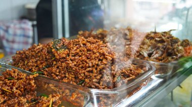 Büfe adı verilen büfelerde çeşitli geleneksel Endonezya menüleri sebzeler, köri sosu, sığır eti, yumurta, tofu, tempeh ile paylaşılmaktadır. Garson yemeği hazırlar. Cam vitrindeki menü. Asya ve Asya yemekleri. Yığın.