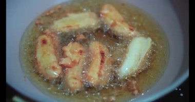 Geleneksel Endonezya Kızarmış Muzları (Pisang Goreng) yüksek açılı çekimi kırsal bir tabakta sunulmaktadır. Bu çıtır çıtır, altın sarısı börekler, çıtır çıtır bir dış hamur ve tatlı, yumuşak bir iç organla popüler bir atıştırmalık..