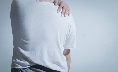 Omuz ağrısı gösteren beyaz tişörtlü biri. Omuz yaralanmaları veya ağrı yönetimi hakkında tıbbi veya sağlıkla ilgili makaleler, bloglar veya sunumlar için uygundur.