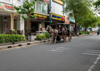 Yogyakarta, Endonezya - 27 Mayıs 2023: Andhong, geleneksel ulaşım Jalan Malioboro, Malioboro caddesi, Endonezya 'nın Yogyakarta kentindeki ünlü bir turizm merkezi.