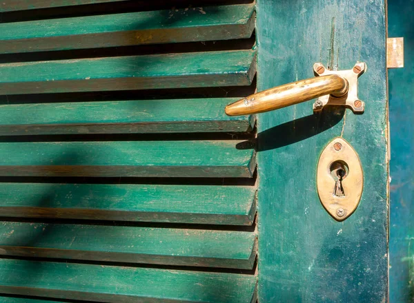 爪哇绿色木门上的一个旧金属门把手 — 图库照片