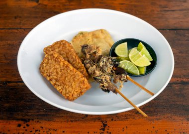 Tempe ve Sate Ayam, Tempeh ve tavuk satay, dilimlenmiş kaffir limonlarıyla beyaz tabakta