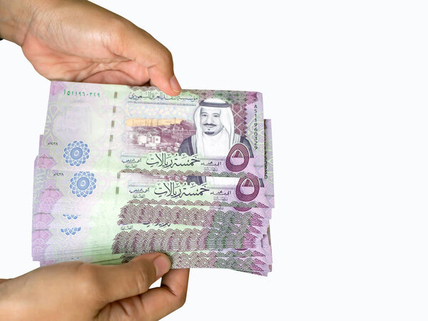 Азиатские дети дают пять риалов, валюту Саудовской Аравии, концепцию благотворительности, дарят, Ид Мубарак. Выбранный фокус и выделенный на белом фоне