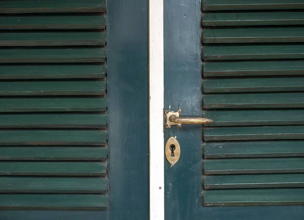 爪哇绿色老式木门上的一个旧金属门把手 — 图库照片