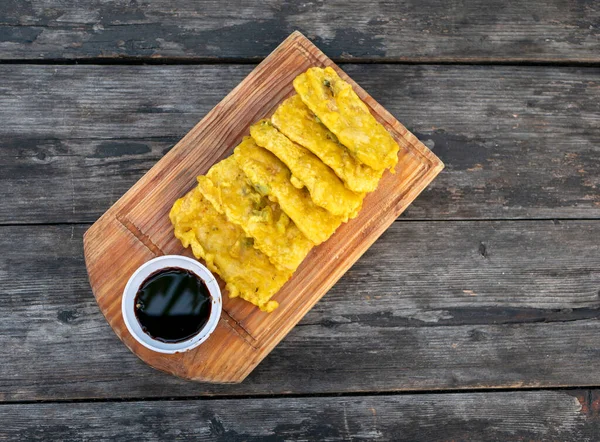 Tempe Goreng Tepung, Tempe Mendoan, un kızartılmış tempeh, Endonezya 'dan geleneksel yemekler, ahşap tahta ve klasik masa..