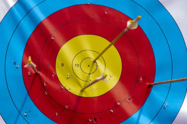 Many arrows hitting the archery target, bulls eye.