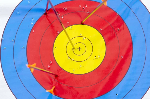 Many arrows hitting the archery target, bulls eye.