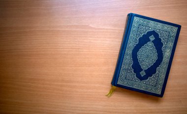 Kuran, Müslümanların kutsal kitabı ahşap bir masanın üzerinde. Boşluğu kopyala.