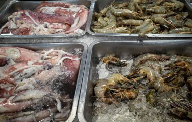 Udang, taze karides, Littopenaeus vannamei, ve Cumi-cumi, Endonezya, Yogyakarta 'daki süpermarkette buzda mürekkep balığı..