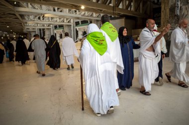 Mecca, Saudi Arabia - June 8, 2024: Hajj and Umrah pilgrim from Iran walking near Masjidil Haram, Great Mosque in Mecca. Saudi Arabia. Hajj 2024. clipart