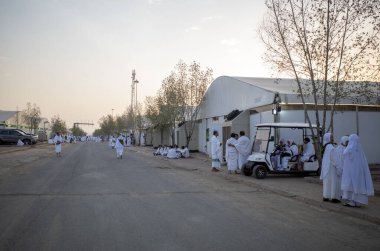 Mekke, Suudi Arabistan - 15 Haziran 2024: Arafat 'taki çadırların yakınındaki çeşitli ülkelerden hacılar beyaz İhram giysileri giyiyorlar. Hac 2024.