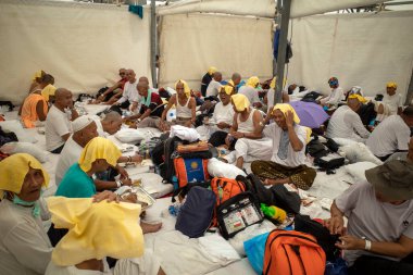 Mekke, Suudi Arabistan - 17 Haziran 2024: Havanın çok sıcak olduğu Mina 'daki çadırlarda Endonezya' dan hacılar. Hac 2024.