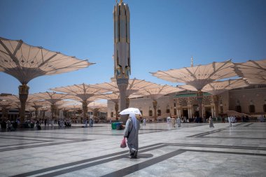 Medine, Suudi Arabistan - 1 Temmuz 2024: Hac ve Umrah, Medine 'deki Hz. Muhammed Camii' ndeki dev otomatik şemsiyeler altında, Suudi Arabistan 'daki Mescid Nabawi olarak da bilinir..
