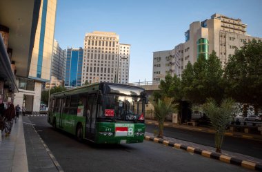 Mekke, Suudi Arabistan - 26 Haziran 2024: Shalawat Otobüs, hac ve umrah yapan Müslüman hacılar için Makkah şehrinin ana caddesinde ücretsiz ulaşım tesisleri.