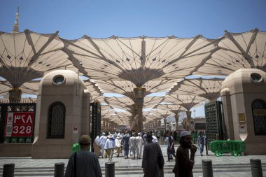 Medine, Suudi Arabistan - 1 Temmuz 2024: Hac ve Umrah, Medine 'deki Hz. Muhammed Camii' ndeki dev otomatik şemsiyeler altında, Suudi Arabistan 'daki Mescid Nabawi olarak da bilinir..