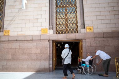 Medine, Suudi Arabistan - 1 Temmuz 2024: Medine, Suudi Arabistan 'daki Nabawi Camii' nin girişinde tekerlekli sandalyeli hacılar.