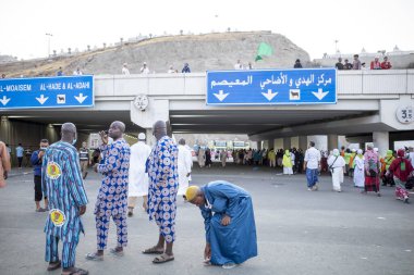 Mina, Suudi Arabistan - 18 Haziran 2024: Hac mevsiminde Suudi Arabistan 'ın Mina kentindeki Jamarat taşlama ayininin yanında duran Afrikalı hacılar.