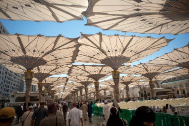 Medine, Suudi Arabistan - 30 Haziran 2024: Hac ve Umrah, Medine 'deki Hz. Muhammed Camii' ndeki dev otomatik şemsiyeler altında, diğer adıyla Mescid Nabawi, Suudi Arabistan.