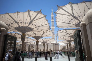 Medine, Suudi Arabistan - 30 Haziran 2024: Hac ve Umrah, Medine 'deki Hz. Muhammed Camii' ndeki dev otomatik şemsiyeler altında, diğer adıyla Mescid Nabawi, Suudi Arabistan.