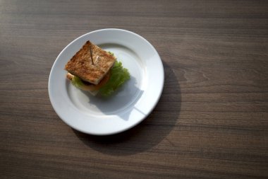 Beyaz tabakta salata ve soğanlı küçük lezzetli bir sığır burger..