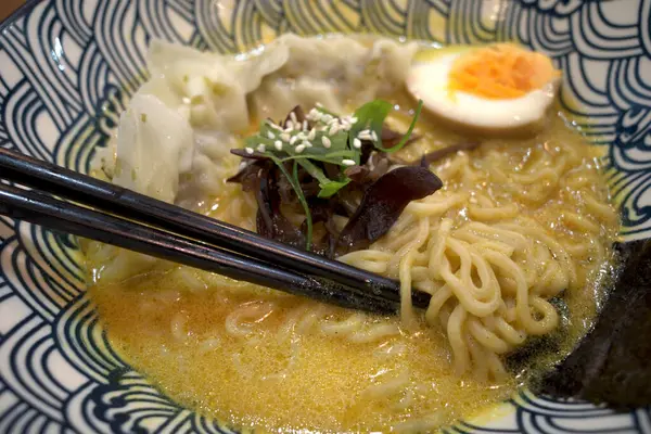 Bir kase ramen eriştesi, çubuklu Japon yemeği, sığ odak..