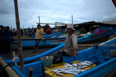 Yogyakarta, Endonezya - 31 Aralık 2024: Balıkçılar Depok, Yogyakarta, Endonezya 'daki bir balıkçı teknesinde çeşitli balık türleri satıyorlar.
