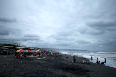 Yogyakarta, Endonezya - 31 Aralık 2024: Depok Beach, Yogyakarta, Endonezya 'da ziyaretçiler ve balıkçı tekneleri.