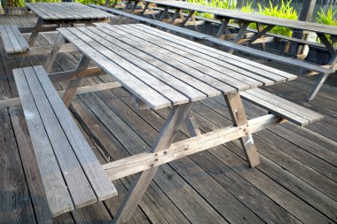 Eski ahşap bir masa, bir bahçede ahşap bir zemin üzerinde..